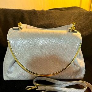 This elegant purse is a beautiful silver snake skin style with gold trim 🩶💛